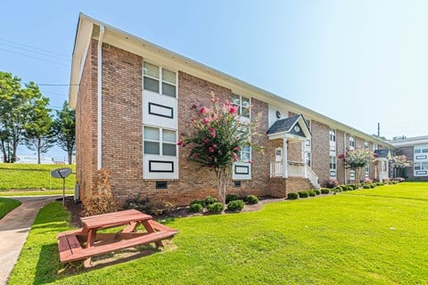 a picnic table in front of a brick building